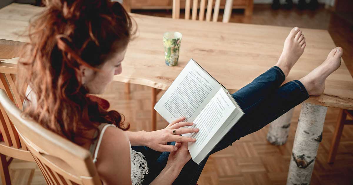 Frau liest ein Buch in bequemer Sitzhaltung