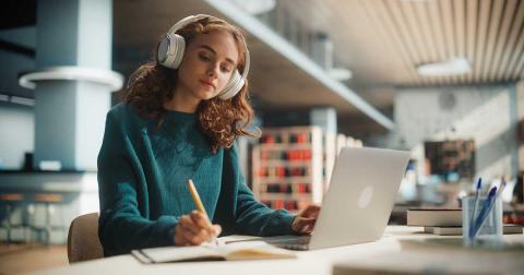 Bild zeigt Studentin in der Uni mit Laptop beim Studieren